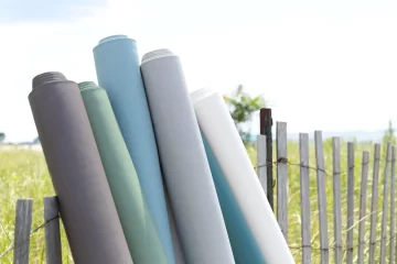 rolls-of-fabric-outside-on-fence