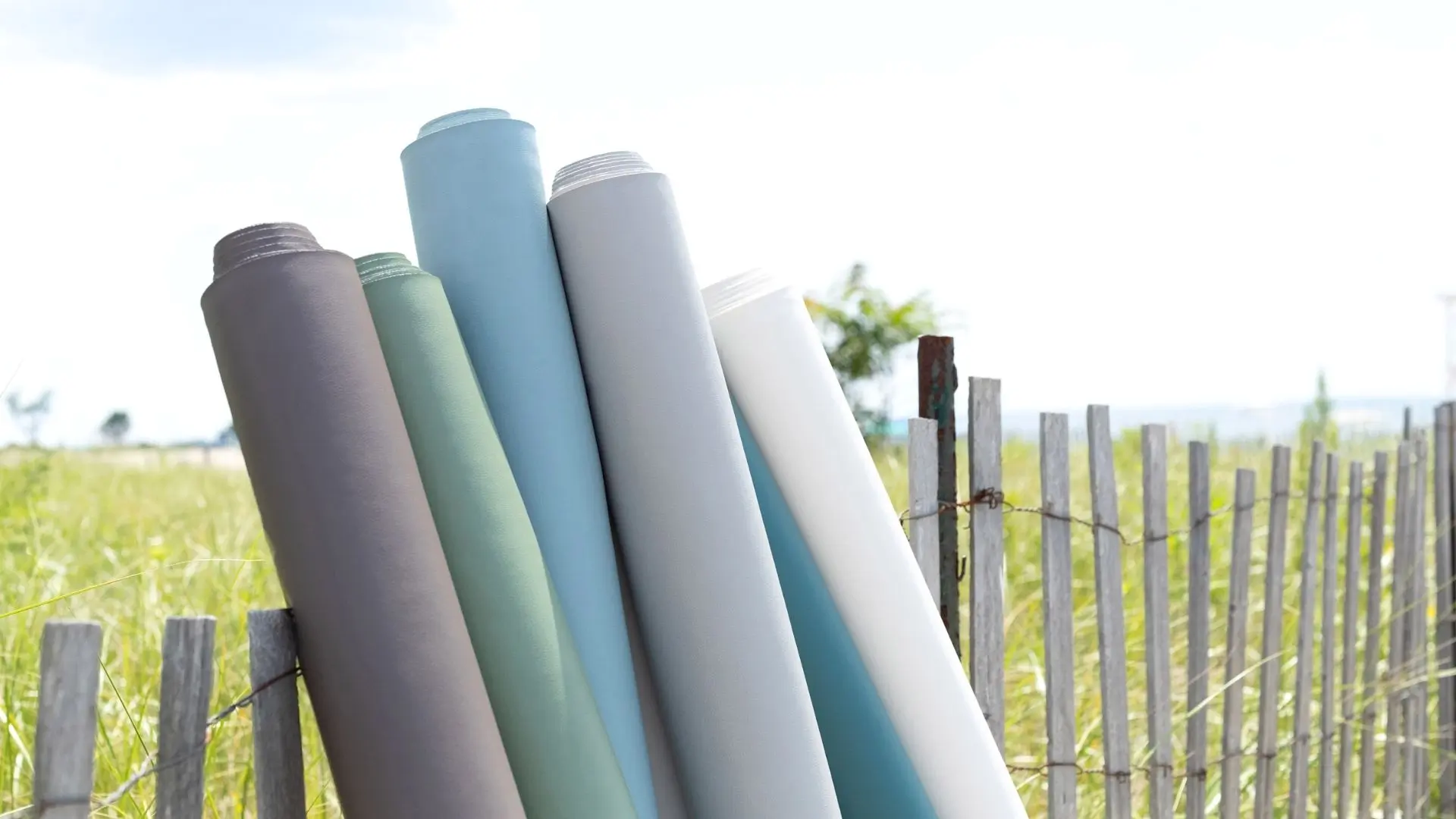 rolls-of-fabric-outside-on-fence