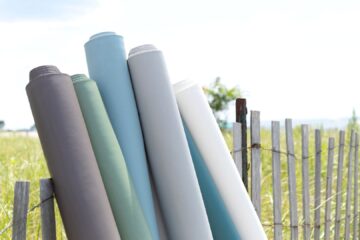 rolls of fabric outside on fence